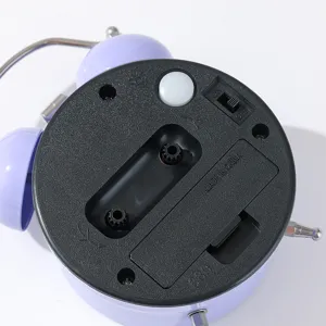 Detailed close-up view of the purple alarm clock back panel with battery compartment and switches.