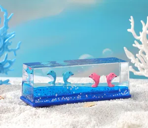 Détail rapproché du jouet liquide rectangulaire avec des dauphins flottants mignons et des paillettes.