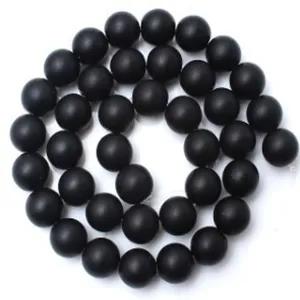Gros plan de perles rondes en agate mate noire pour la fabrication de bijoux de bricolage.