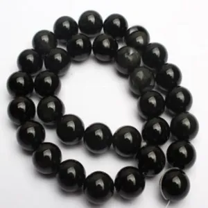 Gros plan detail du fil de perles rondes en agate noire pour creation de beaux bijoux DIY.