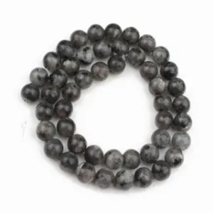 Vue détaillée de brins de perles rondes en agate altérée gris foncé pour la fabrication de bijoux.