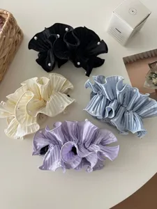 Detailed view of four pleated ruffle satin banana hair clips with elegant pearl accents