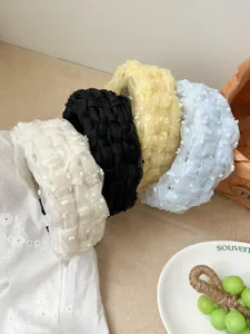Detalle de diademas de malla trenzada en colores blanco, negro, amarillo y azul claro.