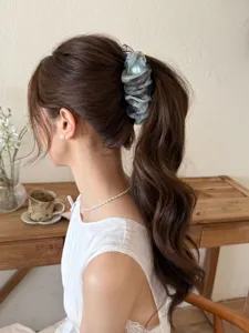 Vue arrière d'une pince à cheveux à fleurs élégante sur une queue de cheval ondulée