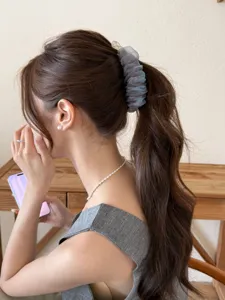 Pince à cheveux élégante en tulle bouffant bleu gris avec de légères paillettes.