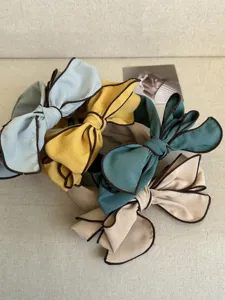 Detailed view of stylish bow headbands in multiple colors with elegant brown piping.