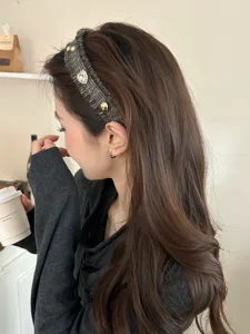 Elegante Detailansicht eines Tweed-Strick-Haarreifens mit glitzernden Strasssteinen am Modell