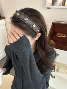 Detail eines eleganten Vintage-Tweed-Haarband mit Strasssteinen und Perlen am Model