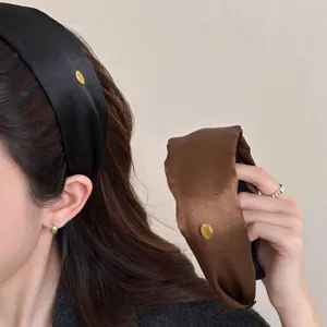 Premium elegant satin wide headband featuring a gold metal label in black and dark brown shades