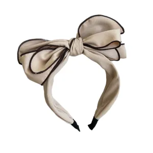 Elegant champagne beige wide headband featuring a large 3D layered fabric bow.