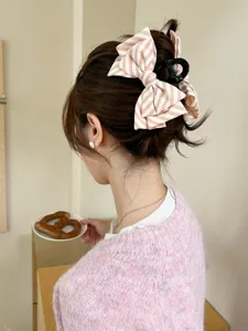 Elegante pinza per capelli con fiocco a righe rosa per uno chignon elegante sul retro.