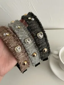 Detailaufnahme von drei eleganten Tweed-Stirnbändern mit Strass und Perlenherz-Verzierungen.