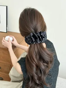 Close-up of elegant black polka dot bubble banana clip accessory on model hair