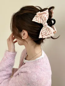 Vista posteriore di una pinza per capelli a fiocco a righe rosa e bianche in uno chignon