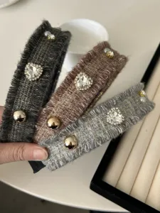 Detailansicht der luxuriösen Herz-Strasssteine und Goldnieten auf Tweed-Haarbändern