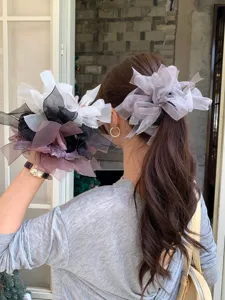 Vue détaillée d'un grand chouchou nœud en organza avec strass dans les cheveux