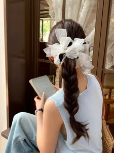 Grand chouchou à nœud en résille blanche avec strass pour coiffure élégante.