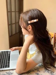 Elegant nude ribbon bow hair clip detail on long wavy hair in lifestyle setting
