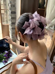 Vue détaillée d'un grand chouchou en organza à nœud violet avec des accents pailletés