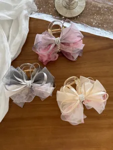Detalle de las pinzas de pelo con lazos de malla floral y perlas de estilo coreano
