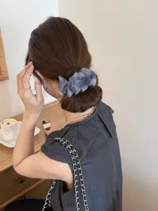 Vue détaillée d'une pince à cheveux élégante en tulle plissé posée sur un chignon
