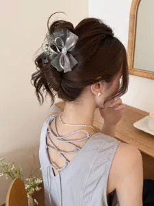 Primer plano de una elegante pinza para el cabello con lazo de malla gris en estilo moño
