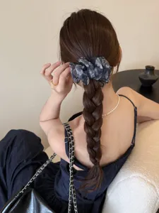 Vue détaillée d'un chouchou en maille fleurie grise vintage sur une tresse française
