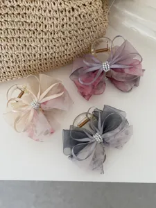 Detalle de las pinzas para el cabello con lazo de malla floral y detalles de perlas