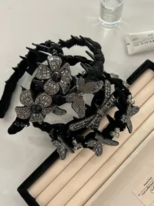 Close-up of black velvet headband with sparkling rhinestone butterflies and flowers