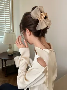 Detailed macro view of an elegant milk tea organza bow hair claw clip for updo styles