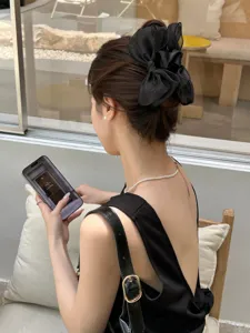 Elegant large black organza bow hair claw clip for sophisticated back bun hairstyle