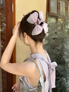 Detail view of an elegant lavender organza bow hair claw clip styled on a model back bun