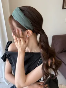 Detail of green fabric wide headband on model showing soft texture and elegant fit