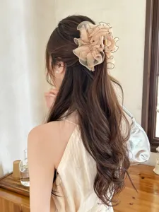 Detailweergave van een elegante beige haarklem met tule strik gedragen op model.