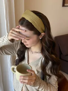 Asian model wearing a mustard yellow wide fabric headband for a high skull top look