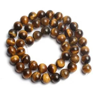 Gros plan de fil de perles rondes en pierre précieuse œil de tigre pour fabrication de bijoux.