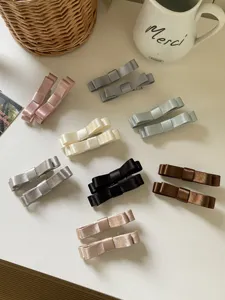 Detailansicht bunter Satin-Schleifen-Haarspangen in verschiedenen Pastell- und Naturtönen.