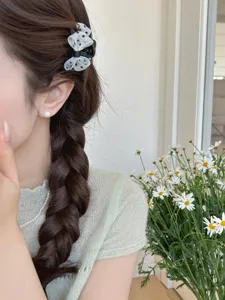 Dettaglio di una mini molletta per capelli con fiocco a pois per frangia e capelli fini