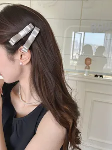 Seitenansicht eines Models mit eleganten grauen Satin-3D-Bogenspangen im koreanischen Stil
