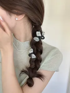 Dettaglio di mini mollette per capelli a fiocco a pois in un'acconciatura a treccia