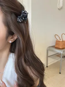 Dettaglio di un mini fermaglio per capelli a fiocco con pois bianchi e neri sul modello