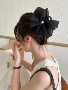Vue détaillée d'une pince à cheveux élégante en tulle noir avec des accents de perles