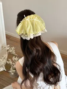 Rear view of a yellow French lace skirt-style hair claw clip on long wavy hair.