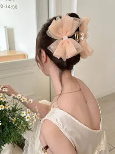Vue détaillée d'une pince à cheveux élégante en résille pêche avec nœud et perles