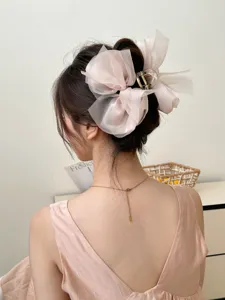 Gedetailleerd overzicht van de elegante oversized roze mesh strik haarklem in een kapsel.