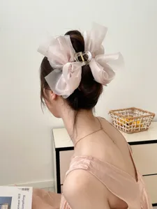 Detail van een elegante grote roze haarklem met strik van gaas voor een chique knot