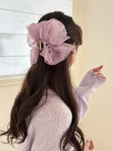 Close-up van een elegante lavendelkleurige haarklem met een grote gaasstrik