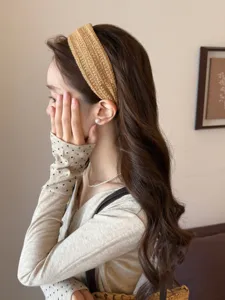 Detailed side view of a brown woven wide headband on a female model's head, high skull top style.
