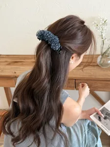 Barrette banane élégante en mousseline à pois bleue dans une coiffure en queue de cheval