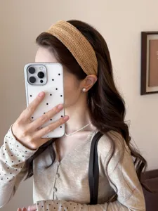 Detail view of a stylish straw-woven wide headband creating a high cranial top effect.